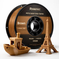 Spool of brown 3D printing filament with models made from it on a white background