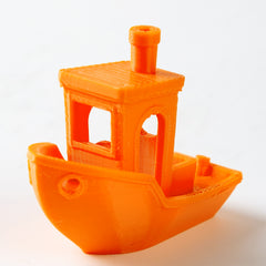 Orange toy boat with a detailed cabin on a white background