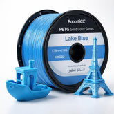 Spool of RobotGCC Lake Blue PETG filament with 3D printed models on a white background