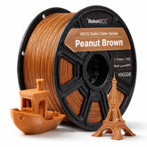 Spool of Peanut Brown 3D printing filament with 3D models of a boat and Eiffel Tower.
