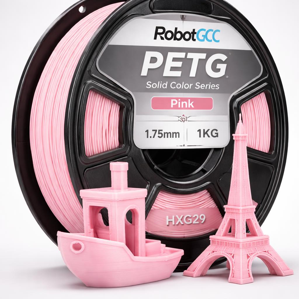 Spool of pink 3D printing filament with small pink models of a boat and Eiffel Tower.