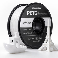 Spool of white 3D printing filament with a small model structure on a white background