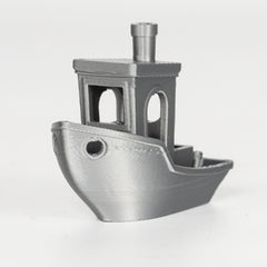 Metallic toy boat with a tower on a white background
