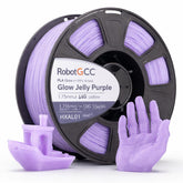 Spool of Glow Jelly Purple 3D printing filament with printed objects on a white background