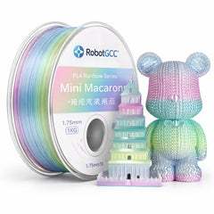 Spool of rainbow-colored 3D printing filament with a model and toy figure on a white background