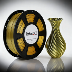 Spool of gold 3D printing filament and a green and gold striped vase on a reflective surface.