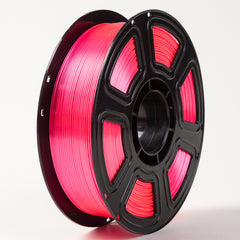 Spool of pink filament on a white background
