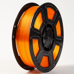 Spool of orange filament on a black reel against a white background