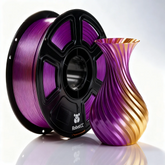 Spool of purple and gold 3D printing filament next to a purple and gold 3D printed vase on a white background