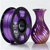 Spool of purple 3D printing filament next to a purple and gold 3D printed vase on a white background