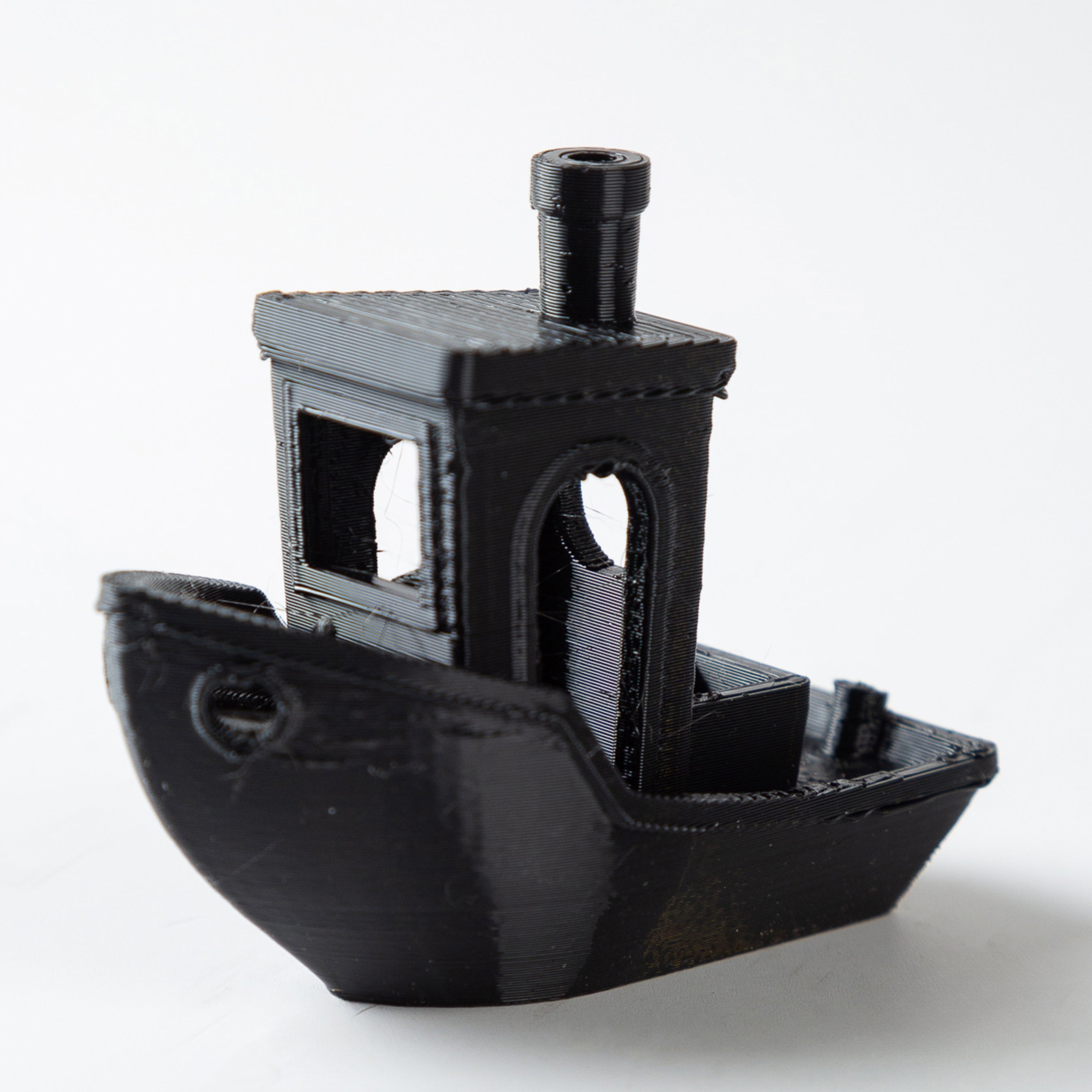 Black 3D-printed model of a ship on a white background
