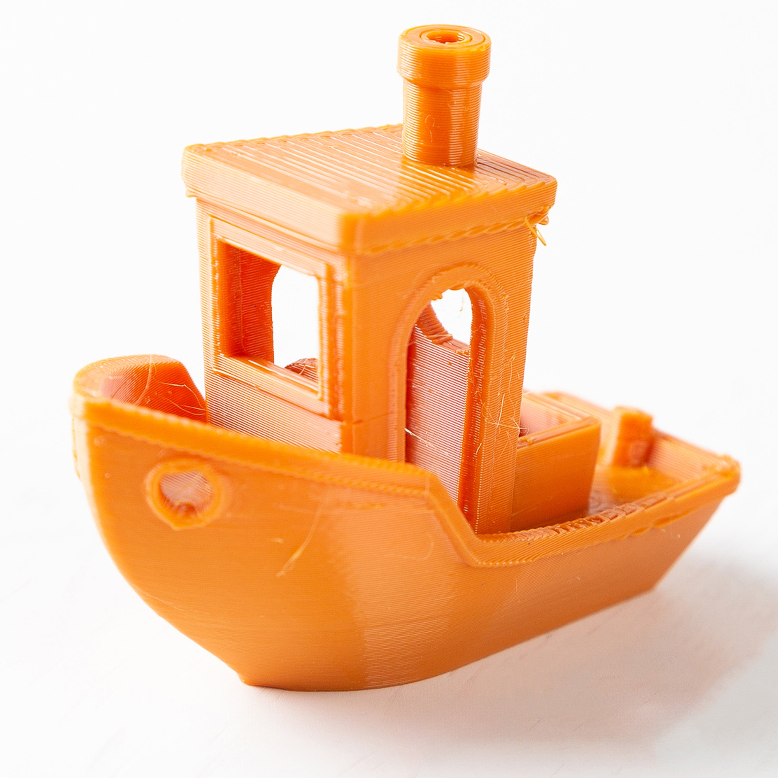 Orange toy boat with a detailed structure on a white background