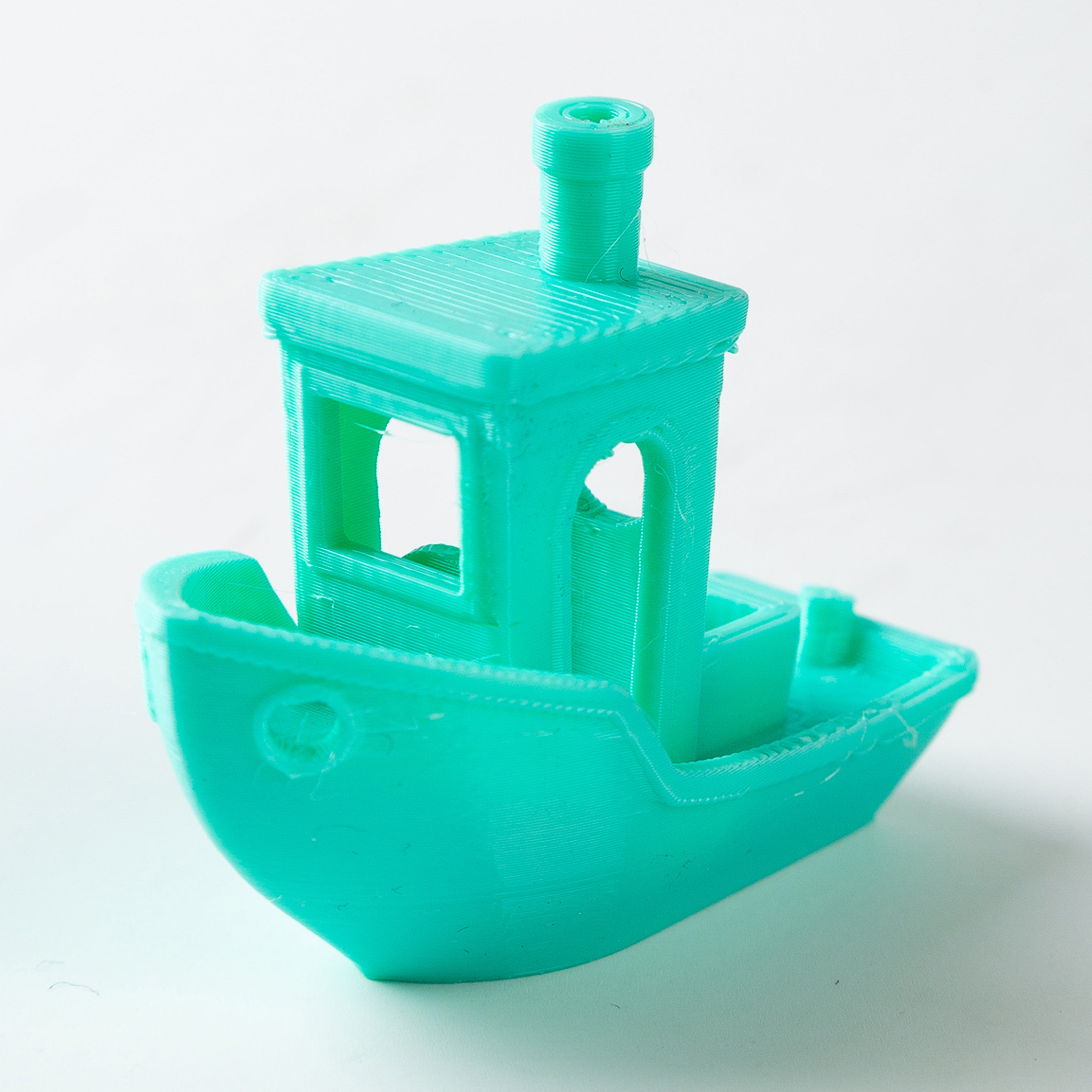 Turquoise toy boat on a white background