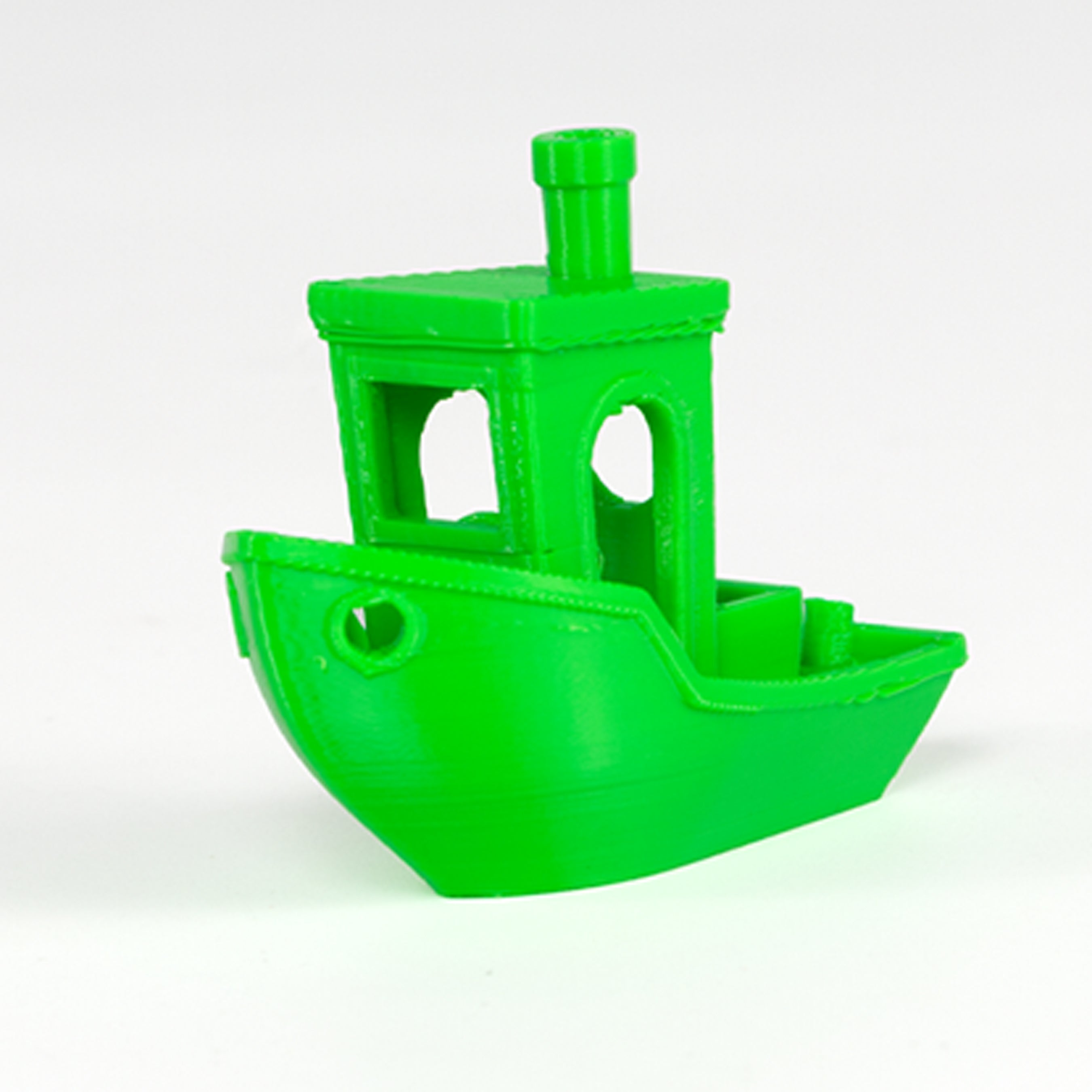 Green toy boat on a white background