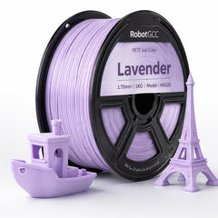 Spool of lavender 3D printing filament with models of a boat and Eiffel Tower made from it.