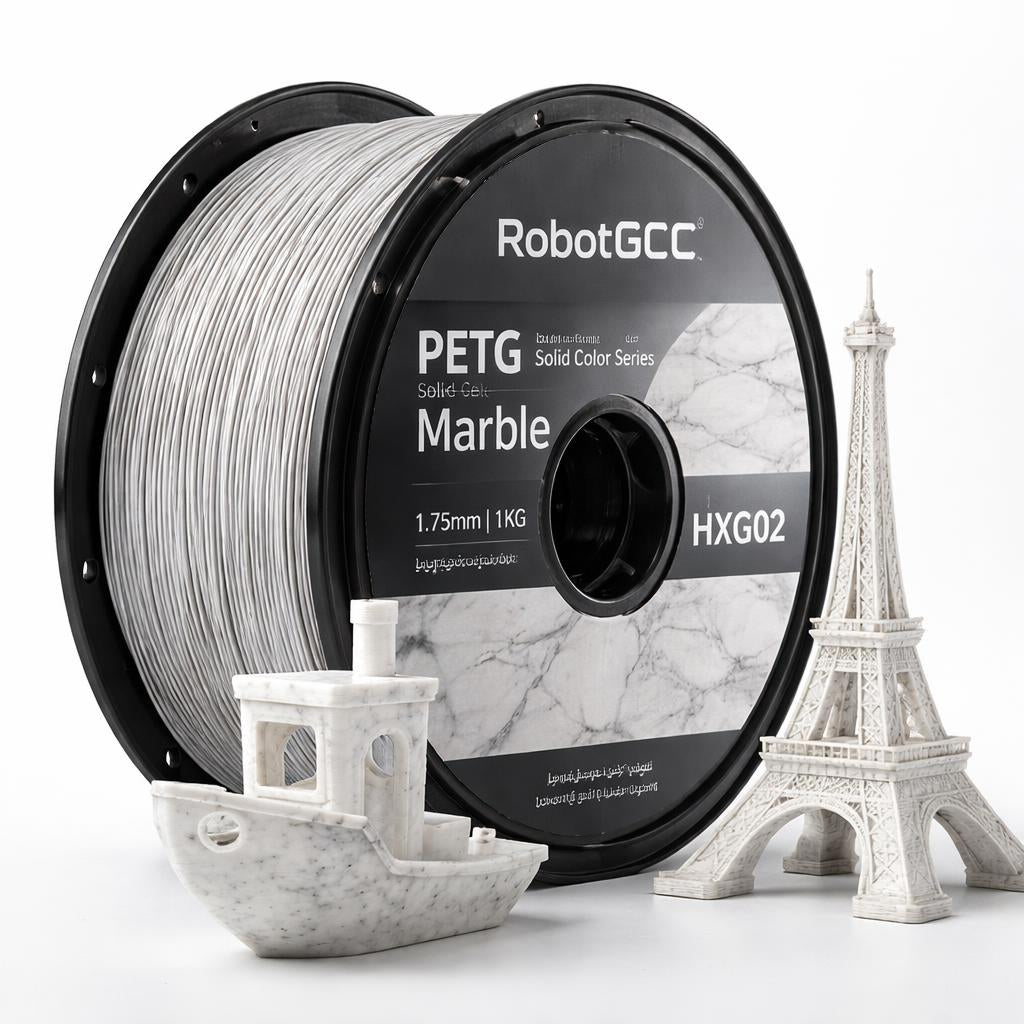Spool of RobotGCC PETG filament with 3D prints of a boat and Eiffel Tower on a white background