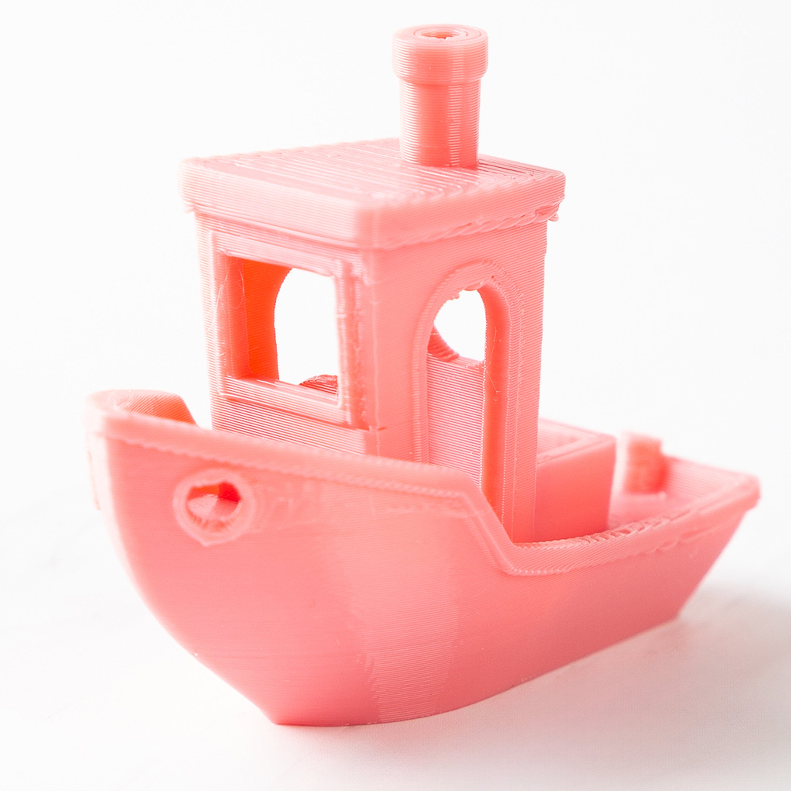 Pink toy boat with a detailed cabin on a white background