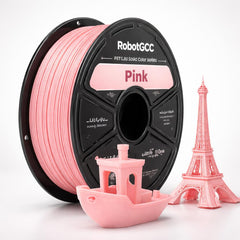 Spool of RobotGCC wheat yellow 3D printing filament with small models on a white background