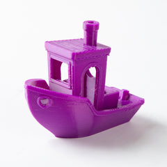 Purple 3D-printed toy boat on a white background
