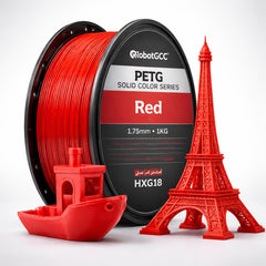 Red 3D printing filament spool with small red models of a boat and Eiffel Tower on a white background
