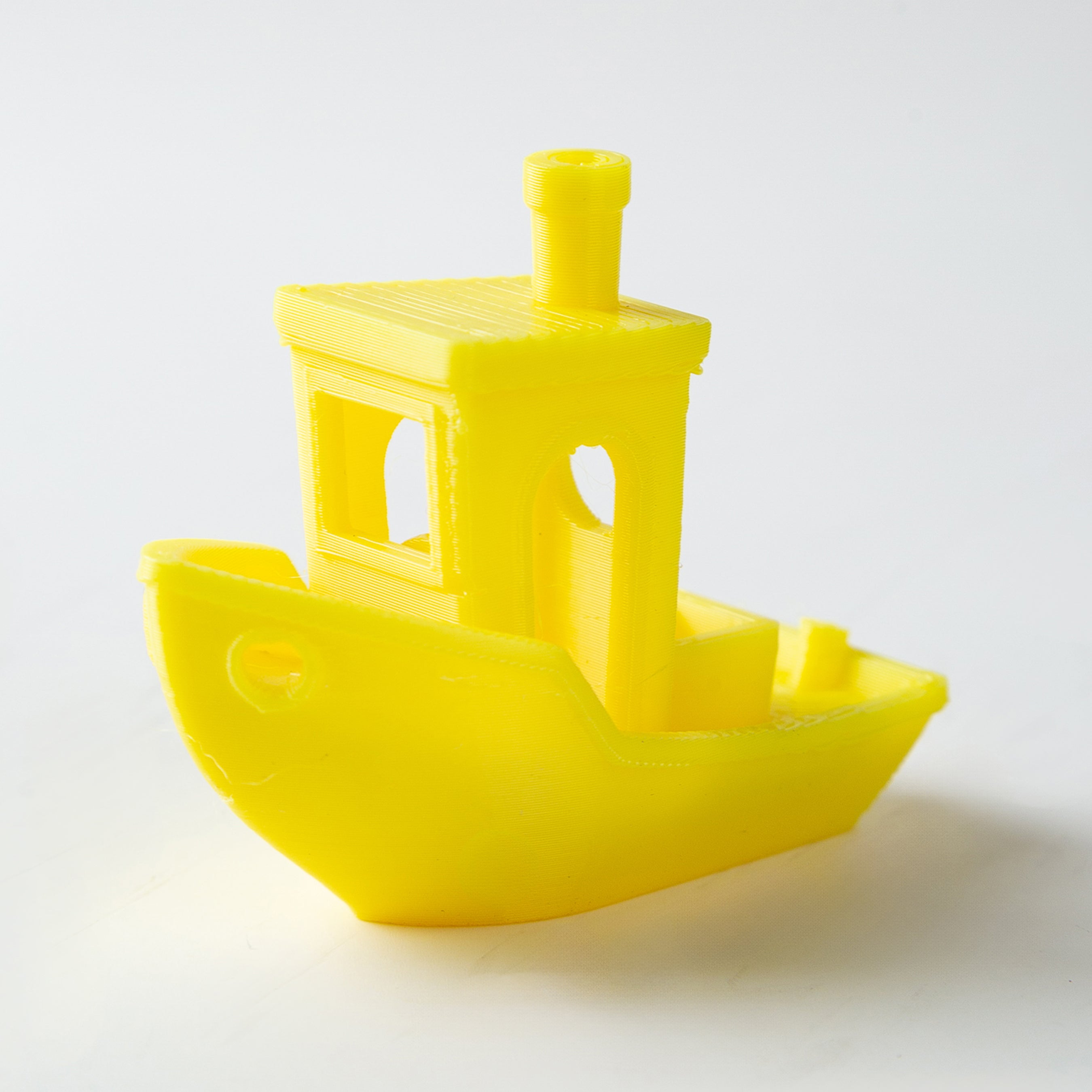Yellow toy boat on a white background