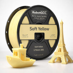 Spool of RobotGCC soft yellow 3D printing filament with 3D prints of a boat and Eiffel Tower.