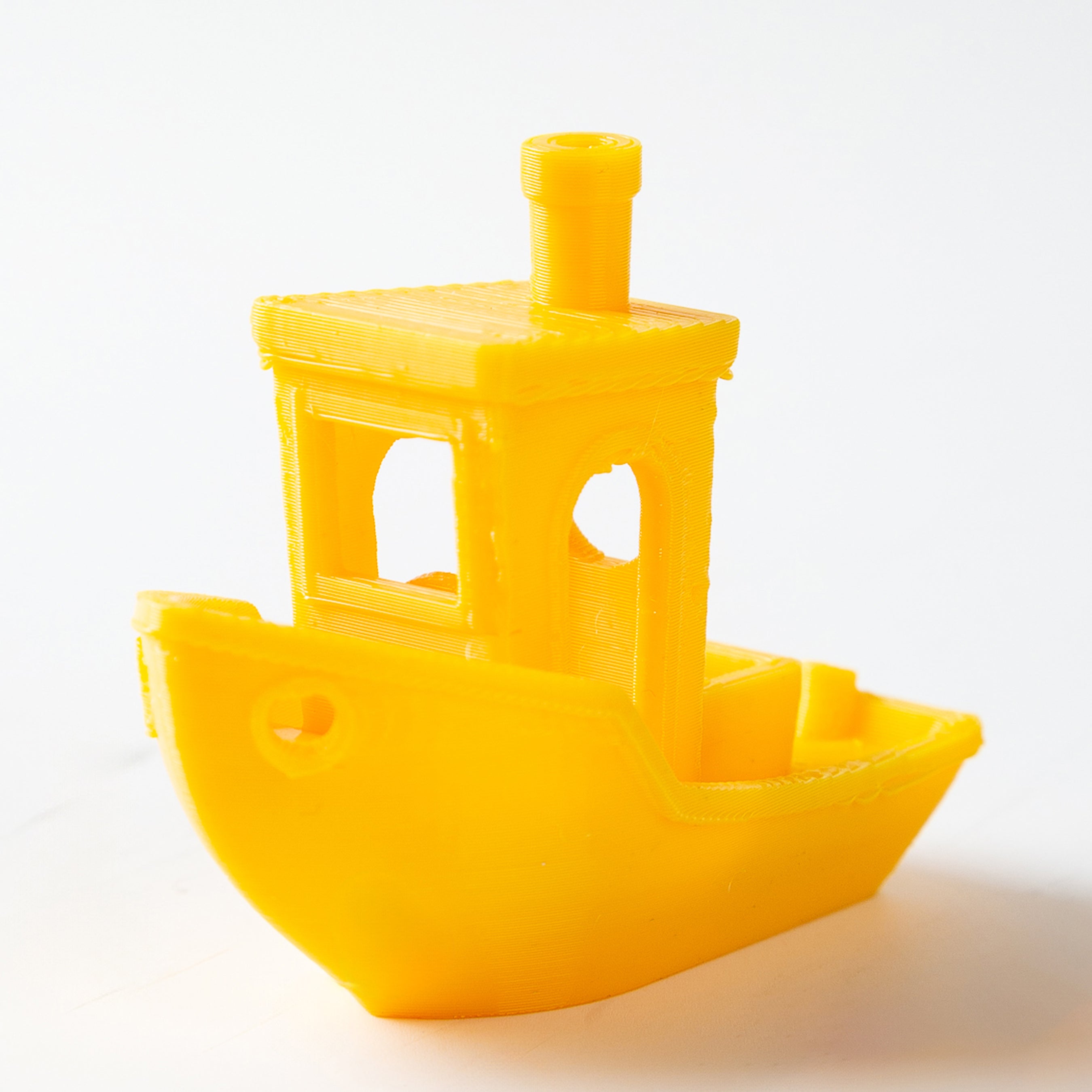 Yellow toy boat on a white background