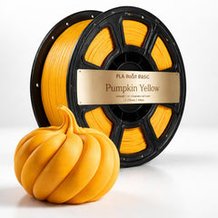 Spool of yellow 3D printing filament with a pumpkin-shaped object on a white background