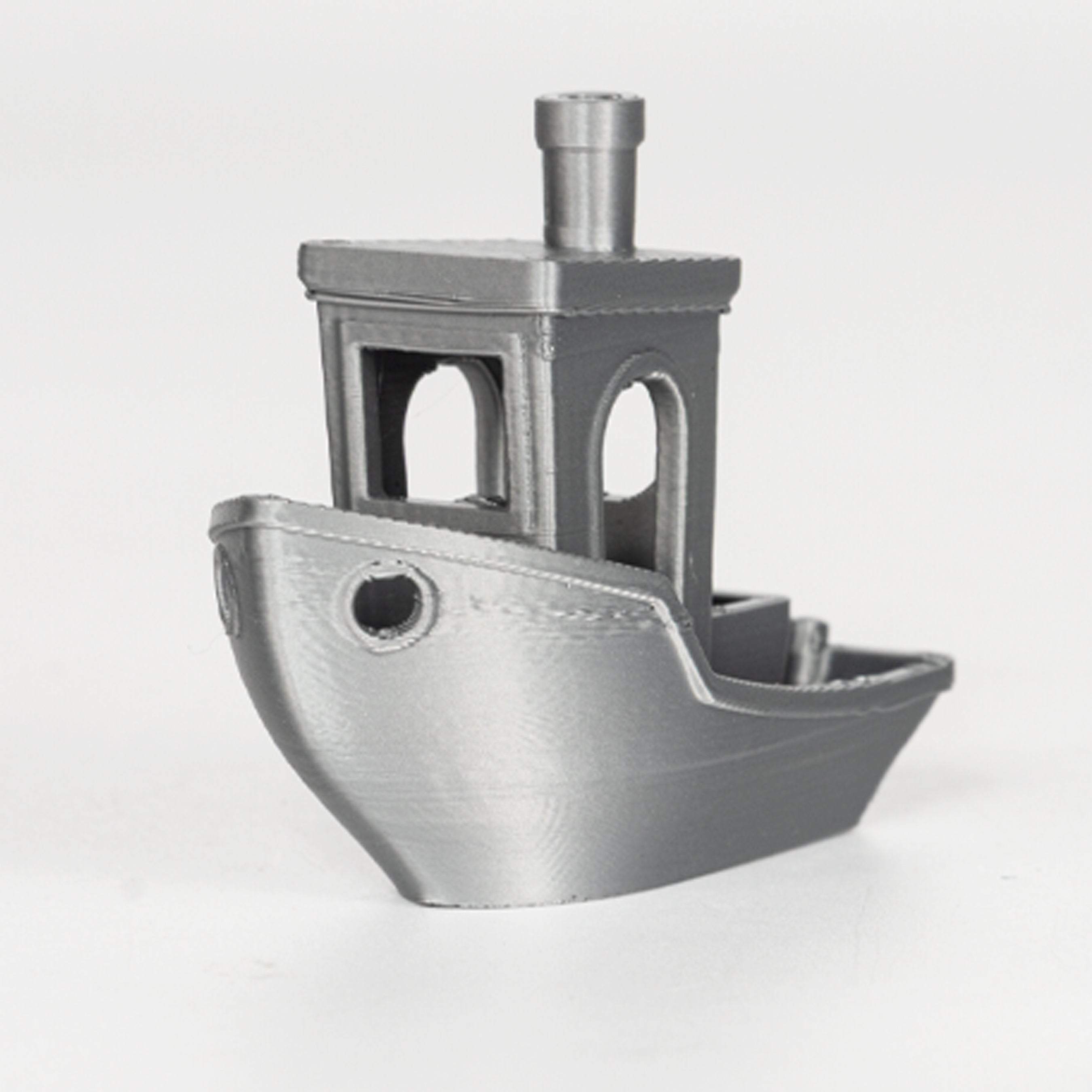 Metallic toy boat with a tower on a white background