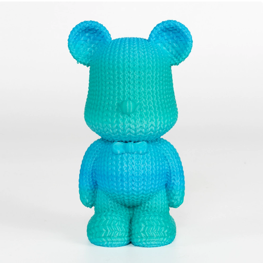 Turquoise knitted bear toy on a white background