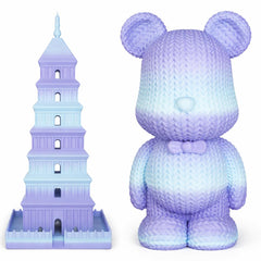 Gradient purple and blue teddy bear next to a tower model on a white background