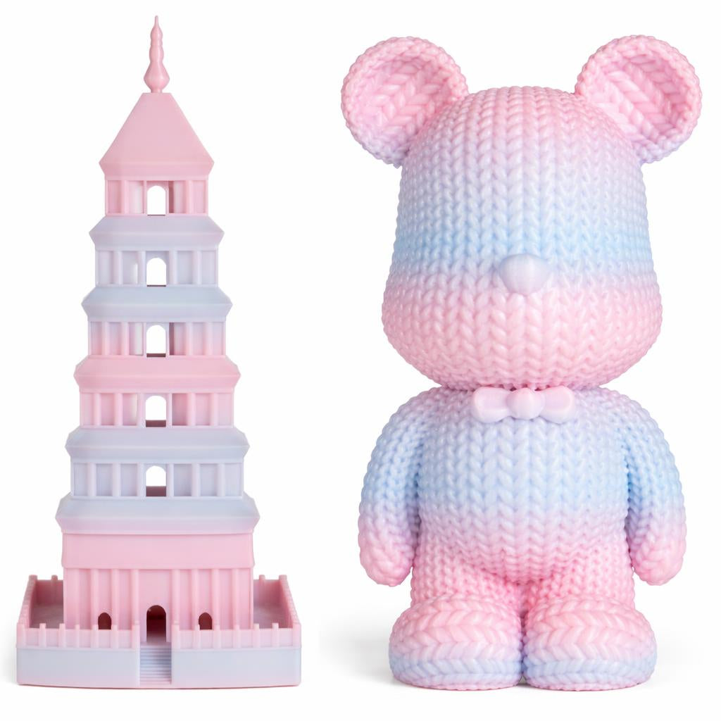Crocheted toy bear and tower with pink and blue gradient on a white background
