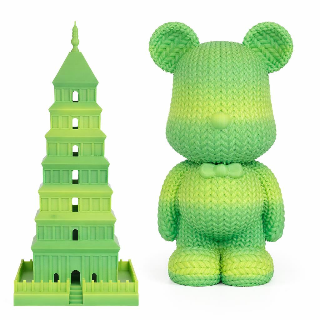 Green toy resembling the Leaning Tower of Pisa next to a green teddy bear on a white background