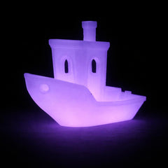 Glowing purple toy boat on a black background