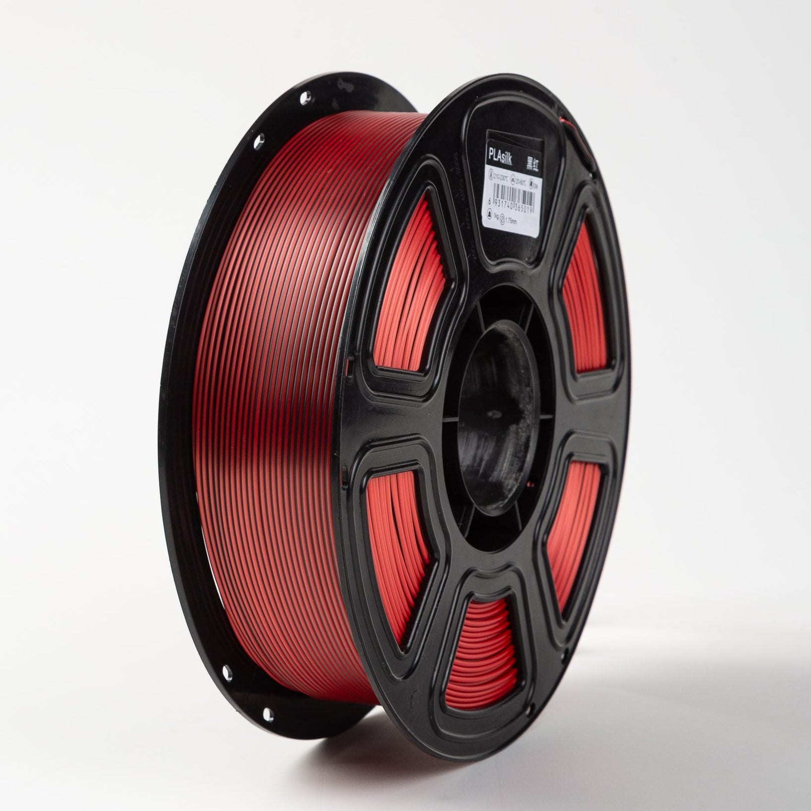 Spool of red filament on a white background