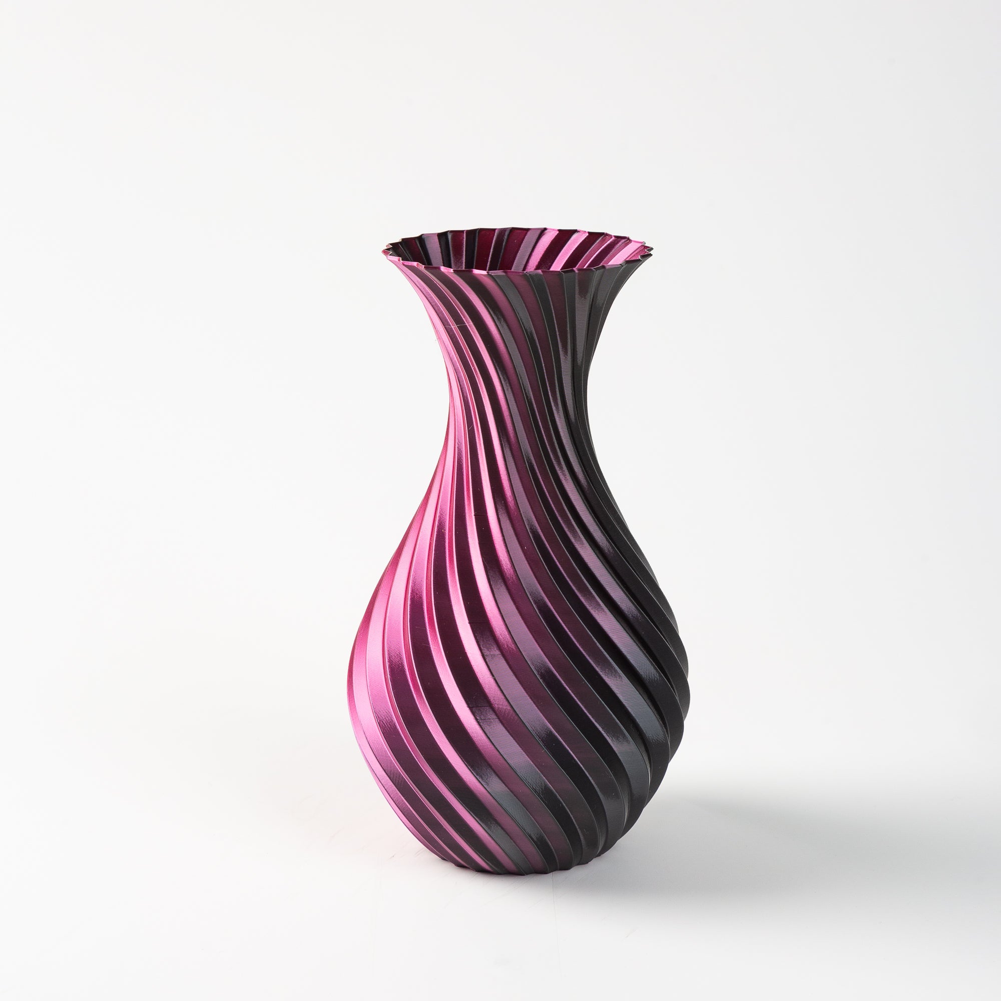 Pink and black striped vase on a white background