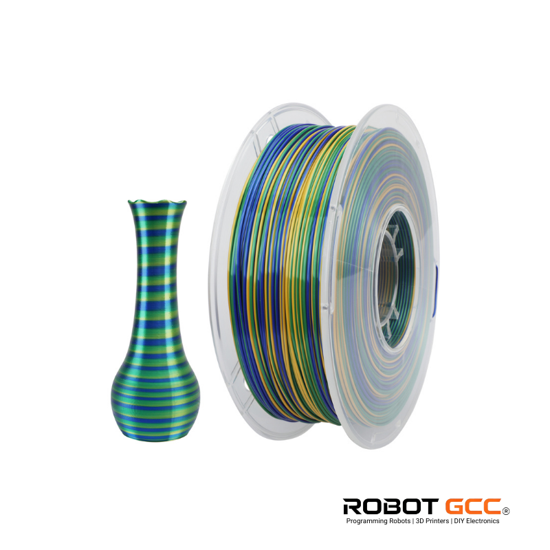 Spool of multicolored filament next to a striped vase on a white background with ROBOT GCC branding.