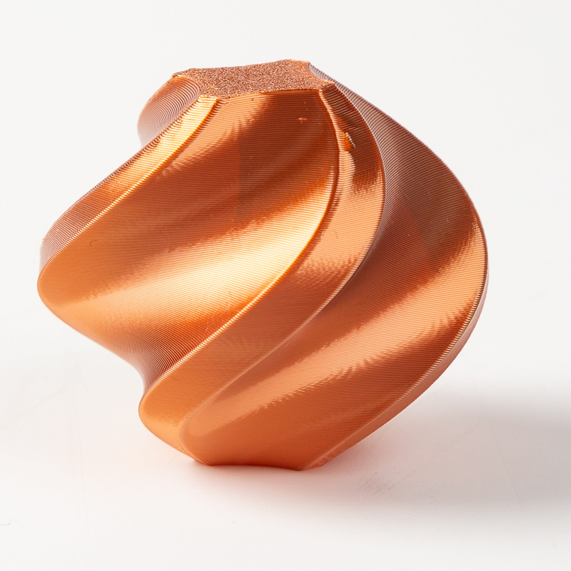 Copper-colored geometric object on a white background