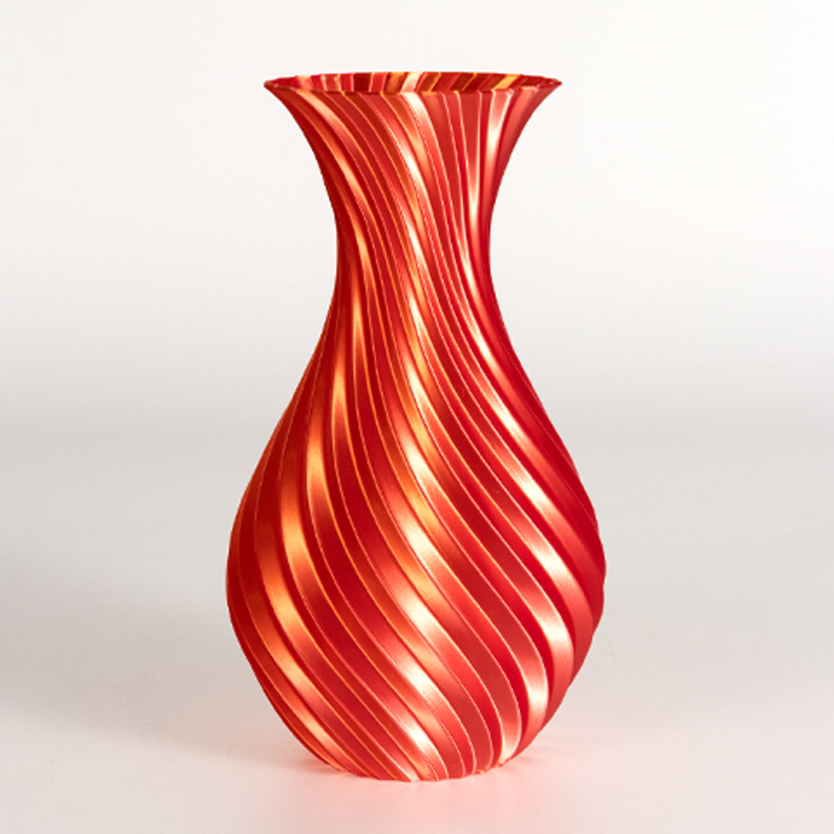 Red glass vase with wavy pattern on a white background