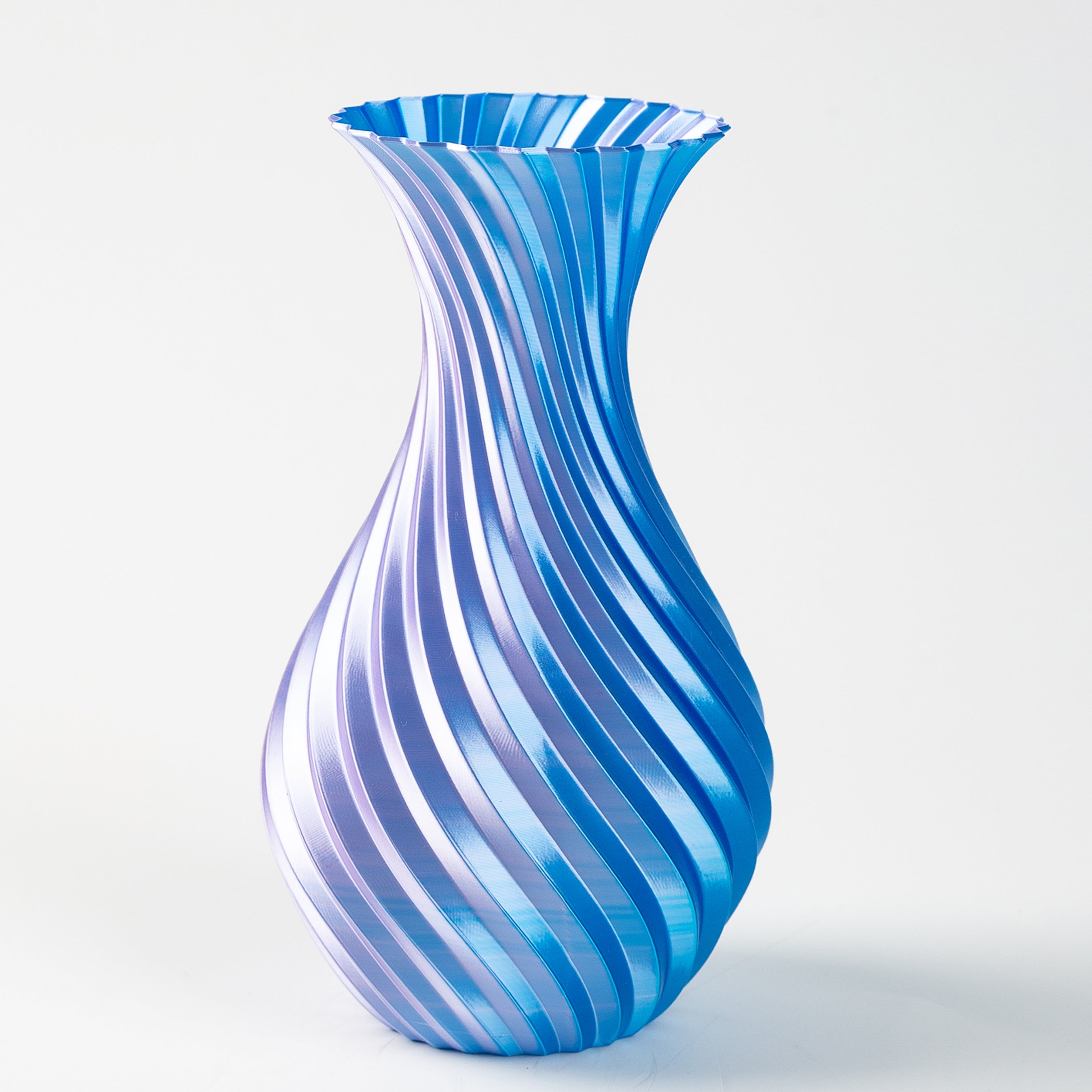 Blue and white striped glass vase on a light gray background