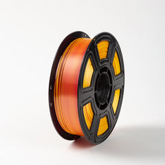 Spool of orange filament on a white background