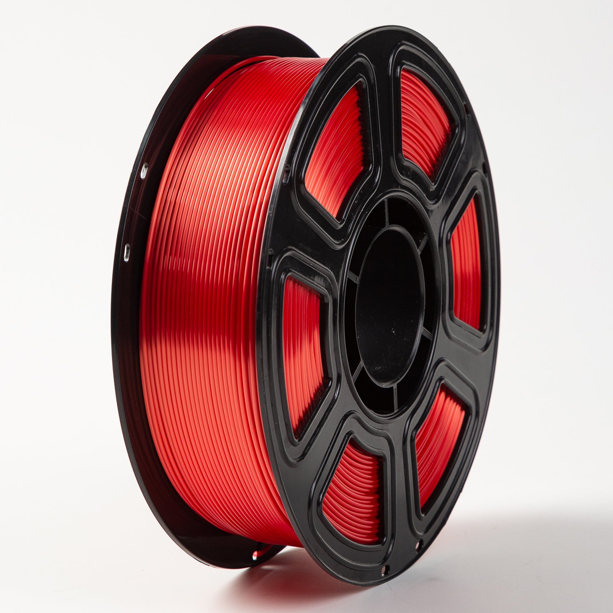 Spool of red filament on a black plastic reel against a white background