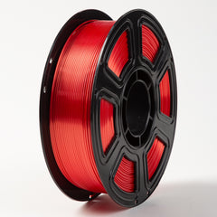 Spool of red filament on a black plastic reel against a white background