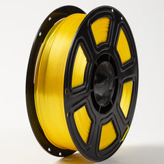 Spool of yellow filament on a black plastic reel against a white background