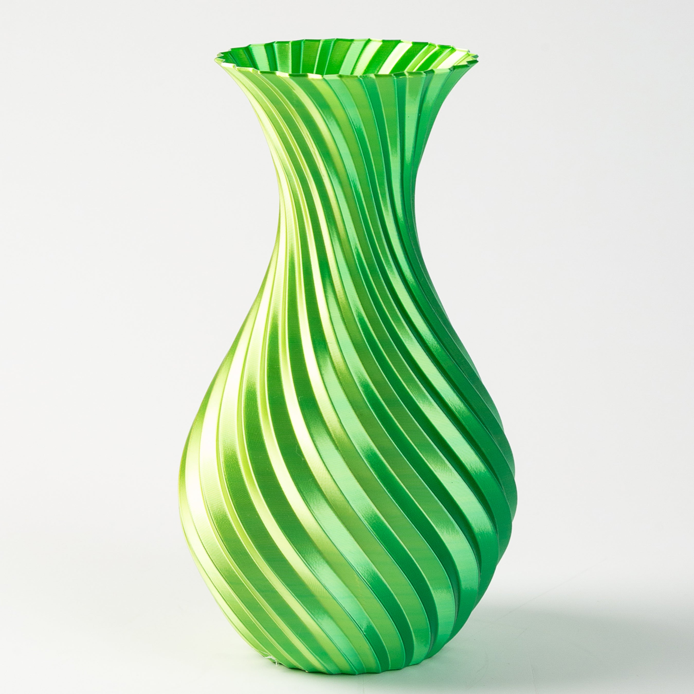 Green and white striped vase on a light gray background