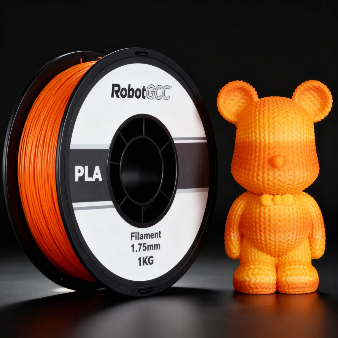 Spool of orange 3D printing filament and a small orange 3D printed bear figure on a reflective surface.