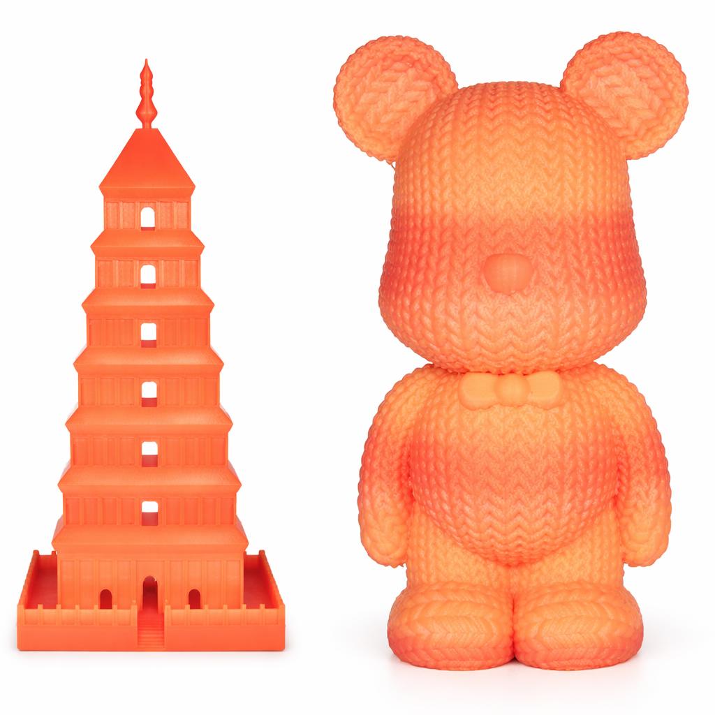 Orange bear-shaped toy next to a tower model on a white background