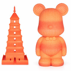 Orange bear-shaped toy next to a tower model on a white background